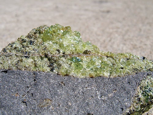 rough peridot in olivine basalt host rock